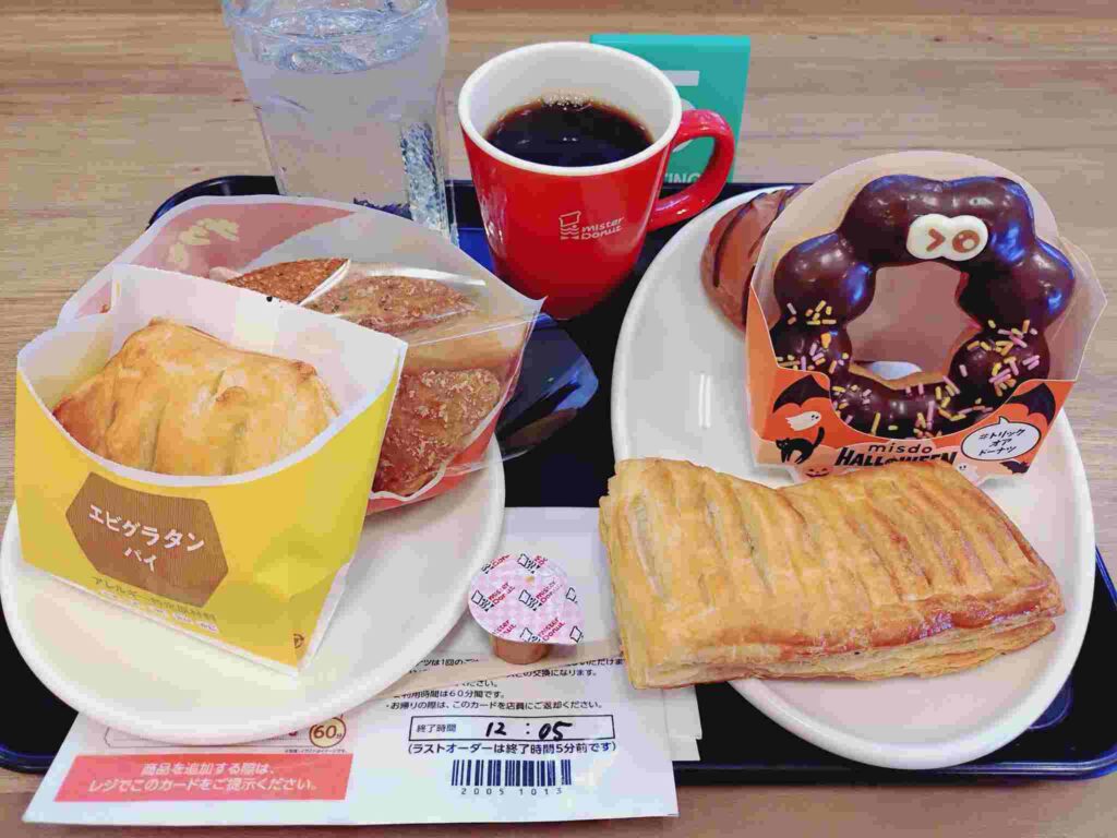 ミスド食べ放題のドーナツとパイとコーヒーがトレーに載っている画像