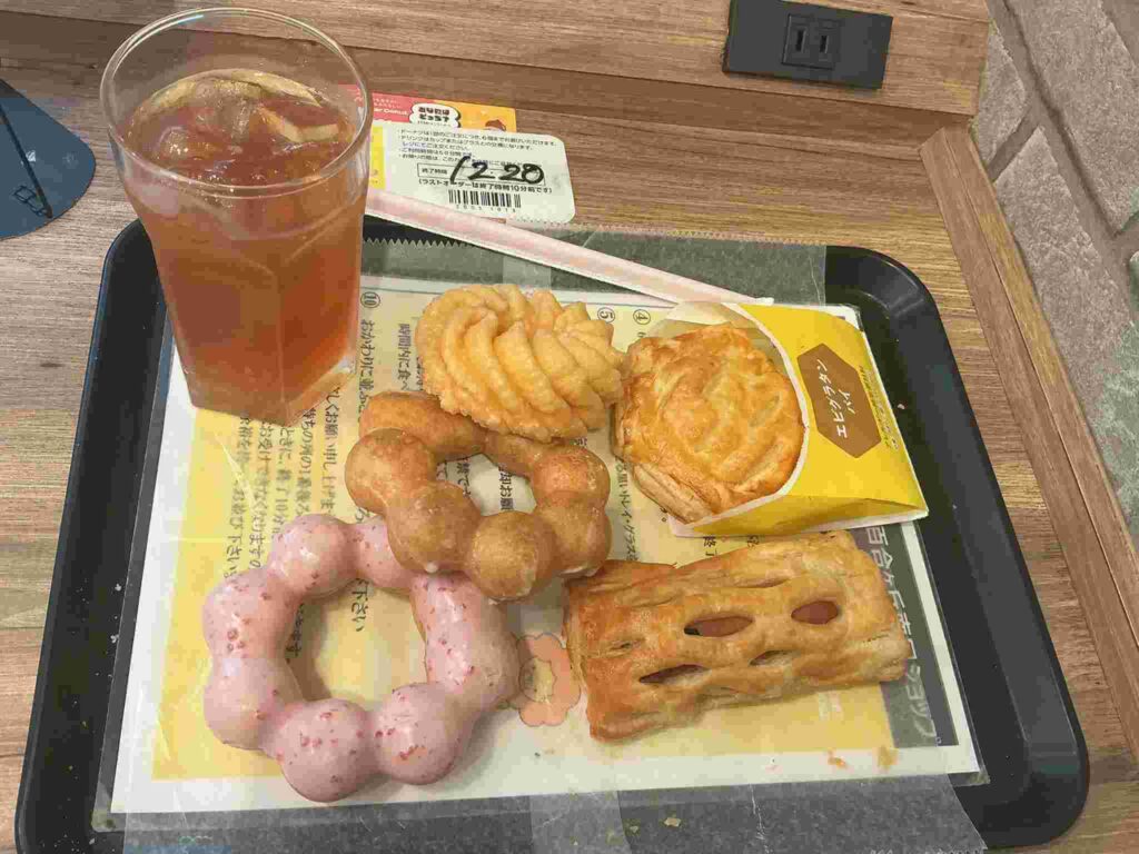 ミスド食べ放題でトレーにドリンクとたくさんのドーナツやパイが載っている画像