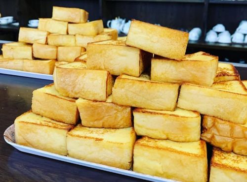 茶房迎賓館 住吉店のカウンターに並ぶフレンチトーストの山の画像