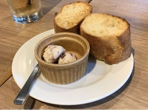 お皿に2つ盛られた厚切りバケットとクランベリークリームチーズの画像