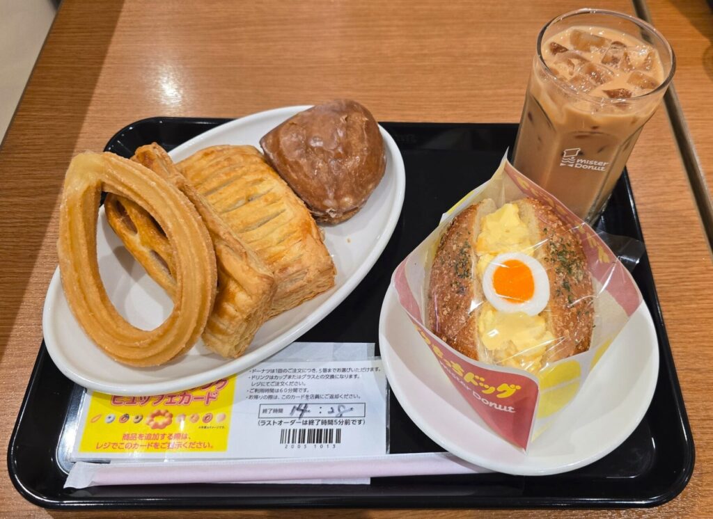 ミスド食べ放題で楽しめるたくさんのドーナツやパイ、ドリンクがトレーに載っている画像