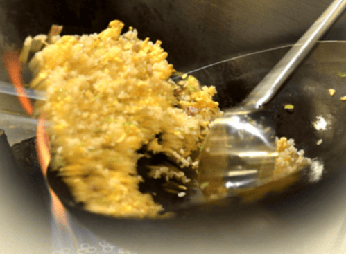 チャーハンを調理するフライパンの画像